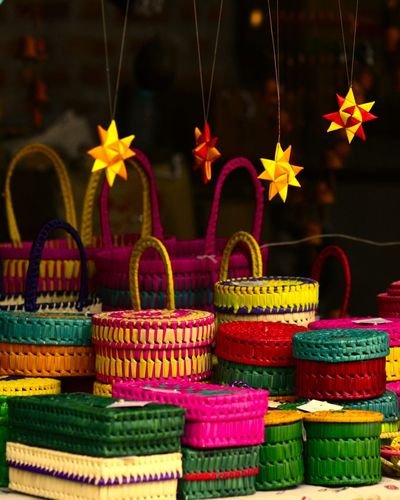 Brightly dyed woven palm-leaf baskets and boxes with hanging paper stars