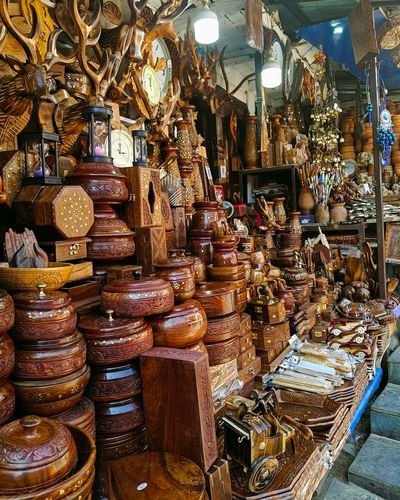 Carved rosewood boxes, bowls and inlaid caskets stacked at a craft workshop