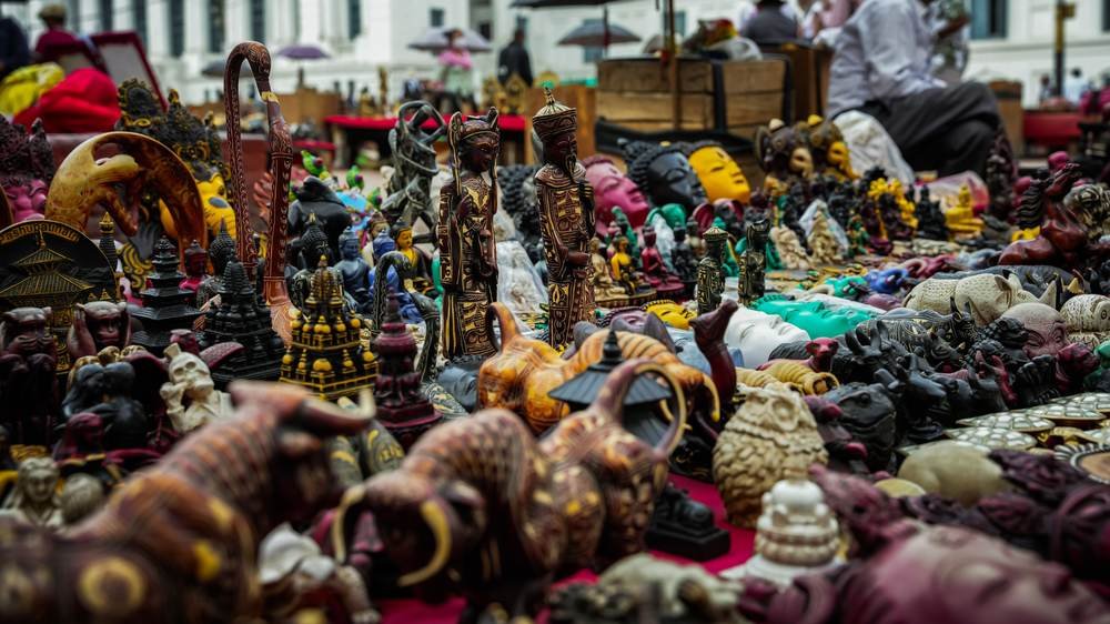 Hand-carved wooden figures and craft goods on an artisan market stall
